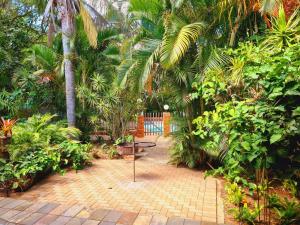 a patio with a table and chairs in a garden at The Estuary Guest Chalets in St Lucia