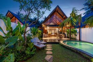 a villa with a swimming pool and a house at Villa Al-Mulk in Ubud