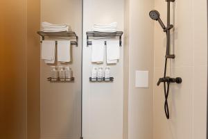 a shower stall with white towels and a shower head at 熹楠丽江古城 in Lijiang +62 photos