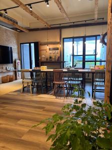 a dining room with a table and chairs and windows at 山沐三薰 2館 可包棟含蔬食早餐 in Shangwu