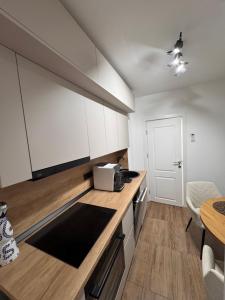 a kitchen with white cabinets and a counter top at Olt view apartament in Călimăneşti