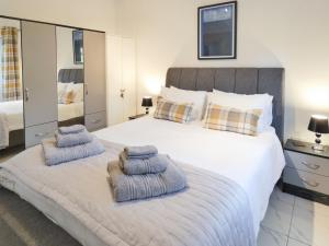 a bedroom with a large bed with towels on it at Railway Cuttings in Falstone