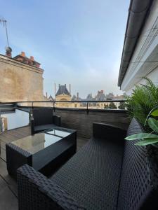 a balcony with two chairs and a coffee table on a building at Le refuge bellifontain in Fontainebleau
