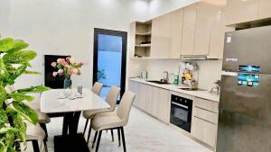 a kitchen with a table and chairs and a refrigerator at Rose house in Ðình Loan +101 photos