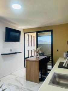 a kitchen with a sink and a table with a tv at Casa Mancera Oaxaca in Yelateni