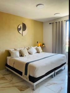 a bedroom with a large bed with white pillows at Casa Mancera Oaxaca in Yelateni