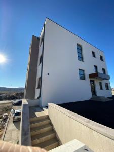 a white building with stairs in front of it at Apartment Delux in Posušje