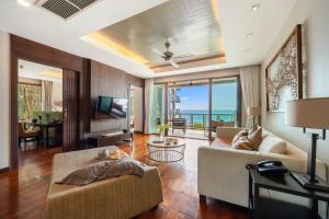 a living room with a couch and a television at CasaVela 213 - 2BR apartment Seaview in Natien Beach
