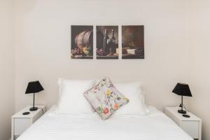 a bedroom with a white bed with two lamps at Villa in the Valley in Pokolbin +8 photos