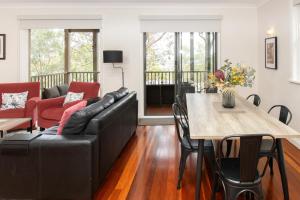 a living room with a couch and a table at Villa in the Valley in Pokolbin