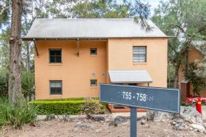 a house with a sign in front of it at Villa in the Valley in Pokolbin