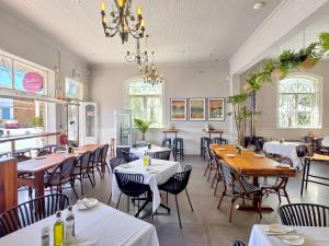 a restaurant with tables and chairs and a chandelier at The Willets Boutique Hotel in Simonʼs Town