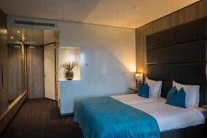 a hotel room with a large bed with blue sheets at Van der Valk Hotel Hoorn in Hoorn +22 photos