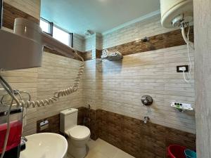 a bathroom with a toilet and a sink at King Castle Mcleodganj-centrally heated and air cooled- Near MALL Road - Free Parking in Dharamshala +64 photos