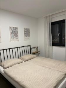 a bed in a white bedroom with a window at Apartment Delux in Posušje