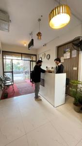two men standing at a counter in a kitchen at Peace Continental Hotel in Islamabad