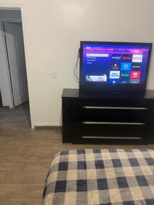 a flat screen tv sitting on a black dresser at Downtown Taylor Private Entry Room 2 in Phoenix