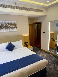 a bedroom with a large bed and a mirror at AL HAYAT HOTEL in Sharjah +28 photos