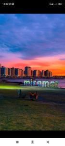 a view of a city skyline at sunset with two benches at CASA TEMPORADA 2027 PARQUEMAr in Miramar