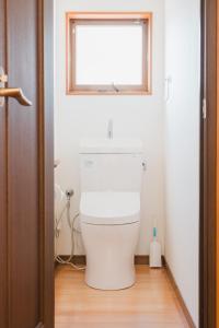 a white toilet in a bathroom with a window at Ao No Mori in Myoko +12 photos