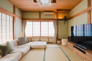 a living room with a couch and a flat screen tv at Ao No Mori in Myoko