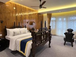 a bedroom with a large bed and a ceiling fan at Cochrane Place By Teesta Hotels in Kurseong +46 photos