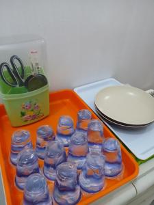 an orange tray with a group of glass jars on a table at K77 Backpackers - Jungle Tours in Medan
