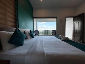 a bedroom with a large bed with a large window at Vagamon Hill Chimes in Vagamon +187 photos