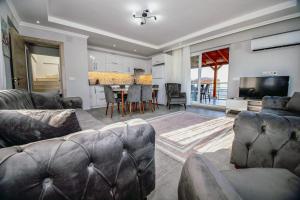 a living room with a couch and a table with chairs at Villas Dogakent in Ortaca