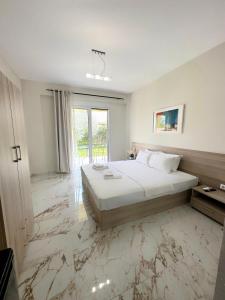 a bedroom with a bed and a marble floor at Avra Yard Suites in Pefkochori