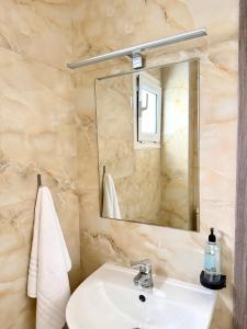 a bathroom with a sink and a mirror at Avra Yard Suites in Pefkochori +10 photos