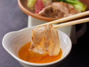 a piece of food in a bowl with chopsticks at Wan Wan Paradise Hamanako in Hamamatsu