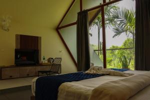 a bedroom with a bed and a large window at Hayashi Resort in Meppādi +112 photos