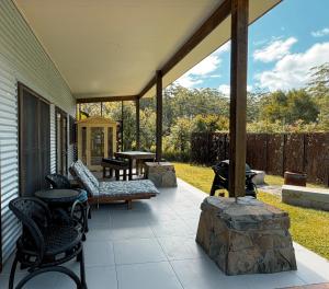 a screened porch with a table and chairs on it at Coffs Coast Mountain Retreat Cabin 1 in Coramba