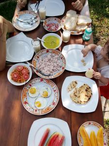 a wooden table topped with plates of breakfast food at Green Heaven in Dickwella