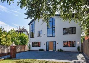 a white house with black windows and a driveway at Glams luxury home in Wolverhampton