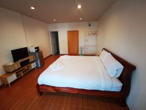 a bedroom with a large bed and a television at Proud Room &wifi 2 in North Pattaya