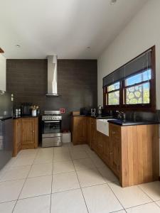 a large kitchen with wooden cabinets and a window at Coffs Coast Mountain Retreat Cabin 1 in Coramba