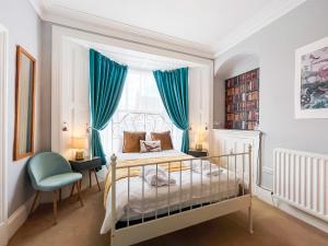 a bedroom with a bed and a window with blue curtains at The Badger Sett in Hinderwell