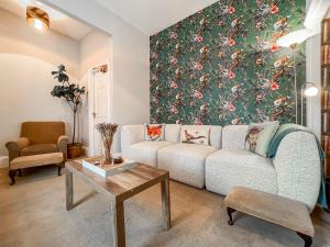 a living room with a couch and a floral wall at The Badger Sett in Hinderwell +21 photos