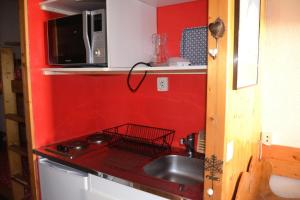 a small kitchen with a sink and a microwave at Résidence Armoise - Studio 3 personnes à Arc 1800 en centre station, proche des pistes et des commerces, dans le village des Villards MAE-1982 in Arc 1800
