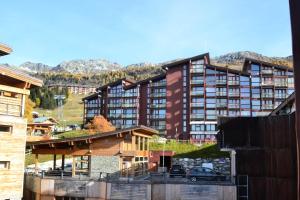 a group of buildings with mountains in the background at Résidence Armoise - Studio 3 personnes à Arc 1800 en centre station, proche des pistes et des commerces, dans le village des Villards MAE-1982 in Arc 1800
