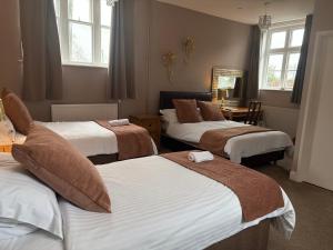 a hotel room with three beds and a table at The Berkeley Arms Hotel in Berkeley