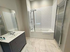 a bathroom with a tub and a sink and a shower at The Berkeley Arms Hotel in Berkeley