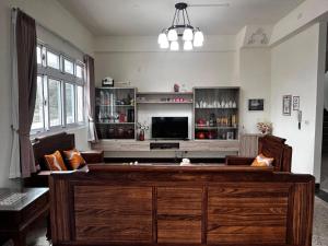 a living room with a couch and a television at Kinmen Xinya Homestay in Jinning