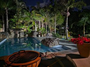 a swimming pool with a chair and flowers in a yard at Vitry Country Estate in Gqeberha