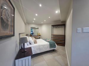 a bedroom with a bed and a table with a lamp at Vitry Country Estate in Gqeberha +47 photos