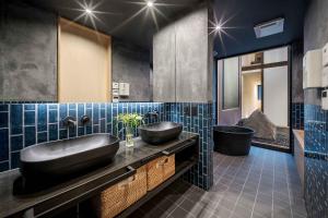 a bathroom with a black sink and a tub at Hanasatomachi Machiya House in Takayama +35 photos