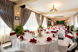 ein Festsaal mit weißen Tischen und roten Servietten in der Unterkunft Classy Hotel & Spa in Battambang + 125 Fotos