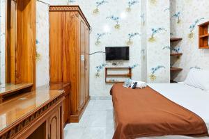 a bedroom with a bed and a tv on the wall at Queen Residence Ancol RedPartner in Jakarta